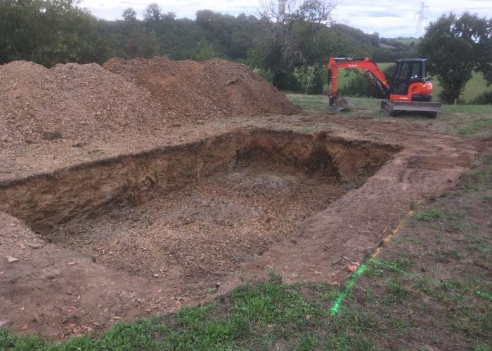 large hole being dug out using a mini-digger